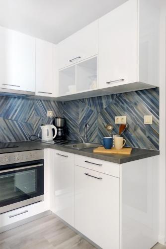 a white kitchen with white cabinets and appliances at Okean Apartments in Ierissos