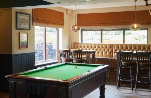 a billiard room with a pool table and a bar at The Broughton Hotel by Greene King Inns in Milton Keynes