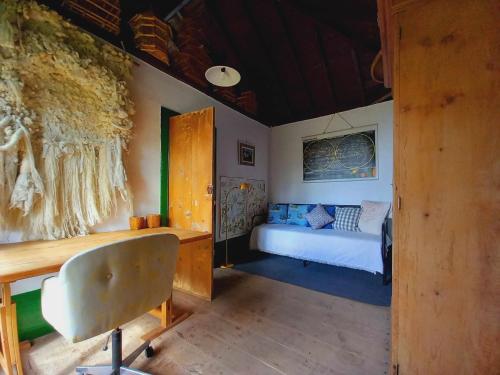 um quarto com uma cama e uma secretária com uma cadeira em Casa Vicente Vista al mar y montaña em Breña Alta