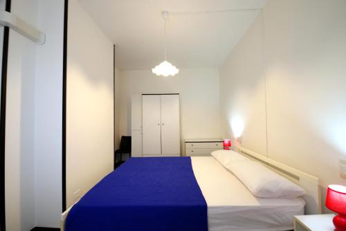 1 dormitorio con 1 cama con manta azul en LAURA confortevole e rilassante appartamento climatizzato a due passi dalla spiaggia en Lido di Scacchi