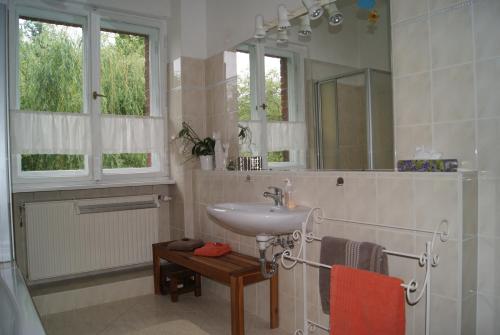 een badkamer met een wastafel en een spiegel bij "Am Griebnitzsee" 14482 Potsdam-Babelsberg in Potsdam