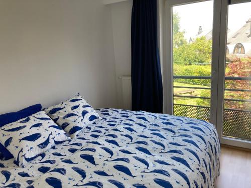 - une chambre avec un lit bleu et blanc et une fenêtre dans l'établissement True Hospitality, à Louvain-la-Neuve