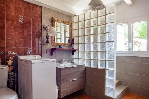 a bathroom with a sink and a toilet and a mirror at Le cabanon de Valérie in Sanary-sur-Mer