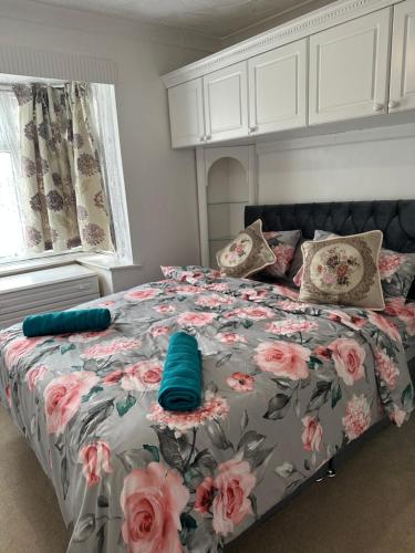 a bedroom with a bed with a floral comforter at Gorgeous 5 bedroom house in Hither Green
