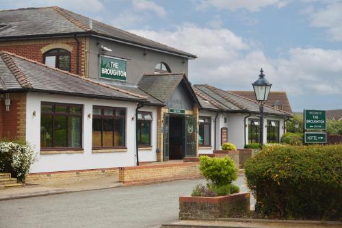 a building with a sign that reads the station at The Broughton Hotel by Greene King Inns in Milton Keynes