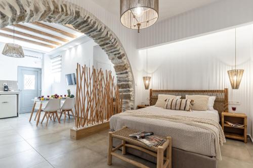een witte slaapkamer met een bed en een tafel bij Philisios Home 1 in Naxos Chora