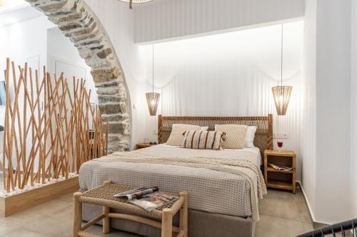 a white bedroom with a bed and a table at Philisios Home 1 in Naxos Chora