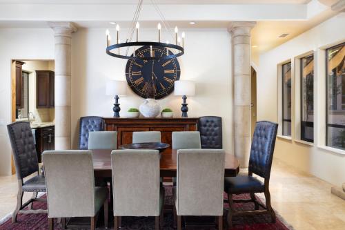 a dining room with a table and a clock on the wall at Palatial Paradise with Breathtaking Views of Red Rock and Stunning Infinity Pool in Sedona