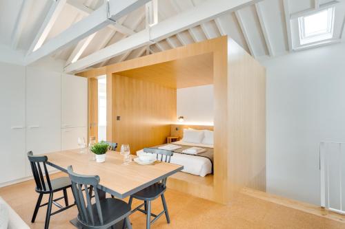 a room with a bed and a table and chairs at Miragaia Apartments by DA'HOME in Porto
