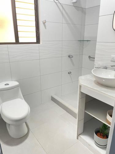 biała łazienka z toaletą i umywalką w obiekcie 3 Min from SJO airport Kaeli w mieście Alajuela