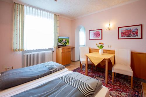 1 dormitorio con cama, mesa y escritorio en Gästehaus Mittmann, en Bad Kissingen