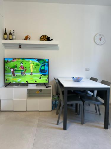 sala de estar con mesa, TV, mesa y TV en Casa San Michele, en Sassuolo