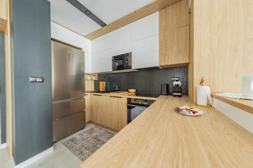 a kitchen with wooden cabinets and a wooden counter top at Łódź Spacious Apartments by Rentujemy in Łódź
