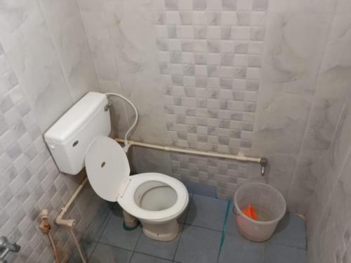 a bathroom with a toilet and a trash can at Tulips near SNS eng college, mullai hall in Pīlamedu