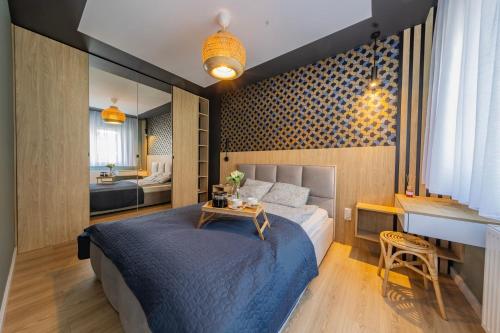 1 dormitorio con cama, escritorio y lavamanos en Łódź Spacious Apartments by Rentujemy, en Łódź
