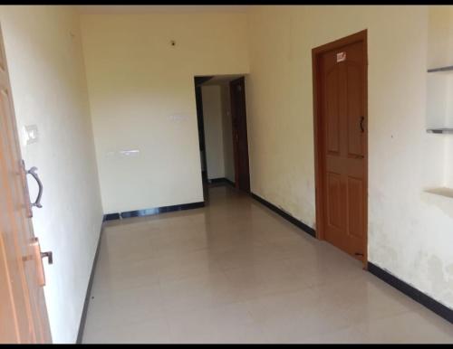 an empty room with a hallway with two doors at Tulips near SNS eng college, mullai hall in Pīlamedu