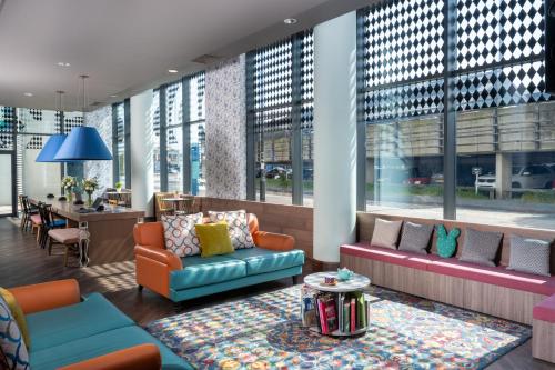 a lobby with couches and a table and windows at Leonardo Hotel Brighton - Formerly Jurys Inn in Brighton & Hove