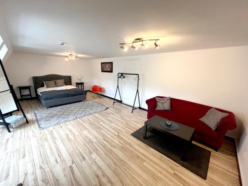 Jacob’s Barracks apartment in Old Town في ريغا: غرفة معيشة مع أريكة حمراء وسرير