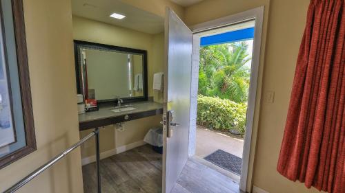 a bathroom with a sink and a mirror at Driftwood Beach Motel in Ormond Beach