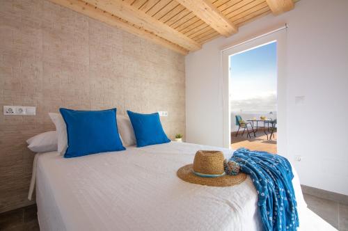a bedroom with a bed with a straw hat on it at Edificio Manuel de Falla Apartamentos in Barbate