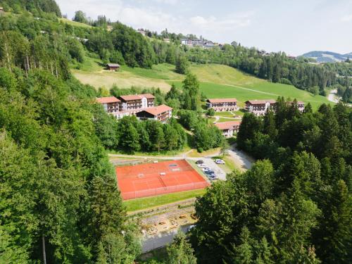 上斯陶芬的住宿－MONDI Resort und Chalet Oberstaufen，享有大楼空中景致,设有网球场