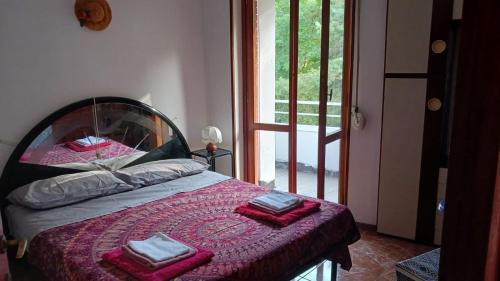 a bedroom with a bed with red towels on it at Lake Maggiore 2 Minutes Apartment in Dormelletto