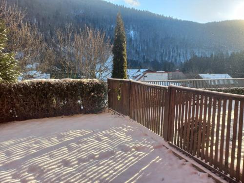 a wooden fence with snow on the ground at WWA SUNLIGHT VIBES in Sinaia