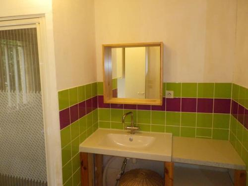 uma casa de banho com um lavatório e um espelho em Petite villa dans copropriété avec piscine et vue mer. em Hyères