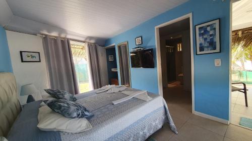 a bedroom with a bed with a blue wall at Pousada Entre as Águas in Imbassai
