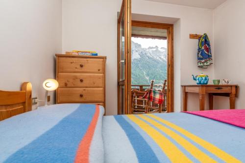a bedroom with a bed and a dresser and a window at Sport & natura in Trentino! in Vigo di Fassa