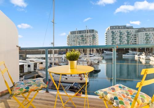 einen Tisch und Stühle auf einem Balkon mit Yachthafen in der Unterkunft On the Water 4 with Free Parking By My Getaways in Brighton & Hove