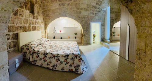 a bedroom with a bed in a stone wall at Le Mura di Gabry in Bari