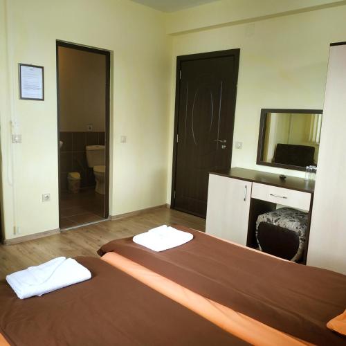 a hotel room with a bed and a mirror at Къща за гости СИАНА in Dospat