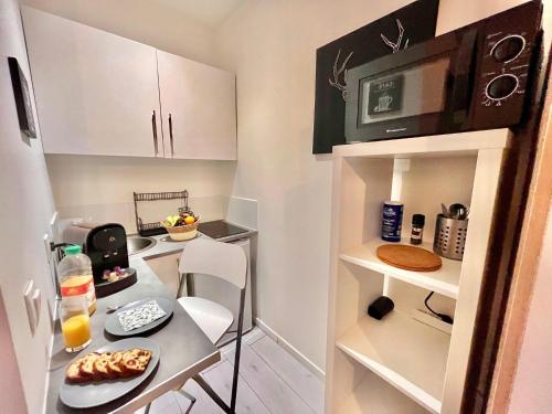 une petite cuisine avec une table et un micro-ondes dans l'établissement Le Studio Courbevoie 2P BAIL MOBILITE, à Courbevoie