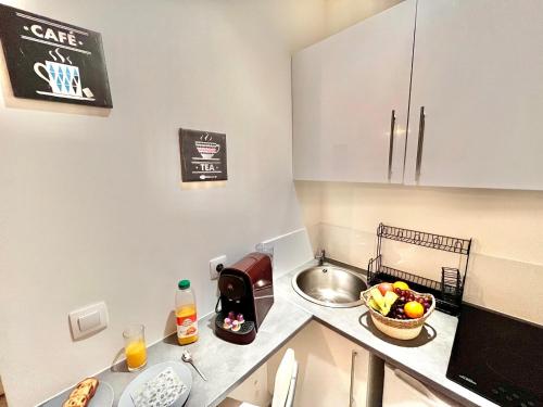 eine Küche mit einem Waschbecken und einer Schale mit Obst auf der Theke in der Unterkunft Le Studio Courbevoie 2P SOZEN C. in Courbevoie