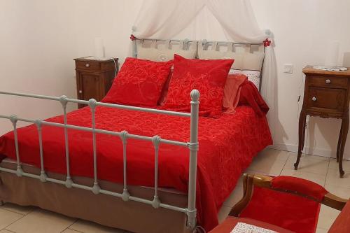 a bedroom with a bed with red pillows at Le Chausse à Brès Chambre d'hôtes 2 in Payzac