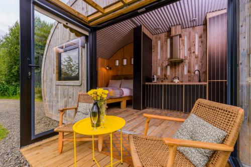 a patio with a table and chairs and a bedroom at Killarney Glamping at the Grove, Suites and Lodges in Killarney