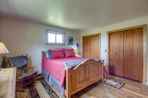 a bedroom with a wooden bed with pink sheets at Red Lodge Vacation Rental with Mountain Views! in Red Lodge