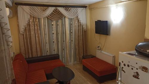 uma pequena sala de estar com um sofá e uma janela em Apartment Zhemchuzhina Ureki em Ureki