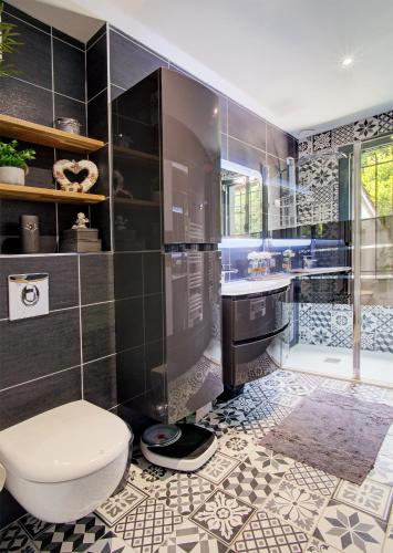 a bathroom with a toilet and a sink and a shower at O jardin des Sens -Séjour Bien-être & détente &Jacuzzi in Béziers