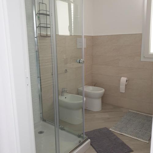 uma casa de banho com uma cabina de duche em vidro e um WC. em Casa Aurora em Terrasini