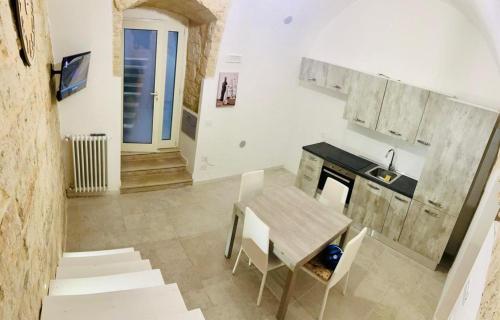 uma pequena cozinha com uma mesa e um lavatório em Le Mura di Gabry em Bari