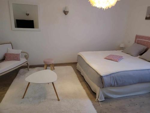 勒韋的住宿－Chambre d'hôte，一间卧室配有一张床、一张桌子和一张沙发