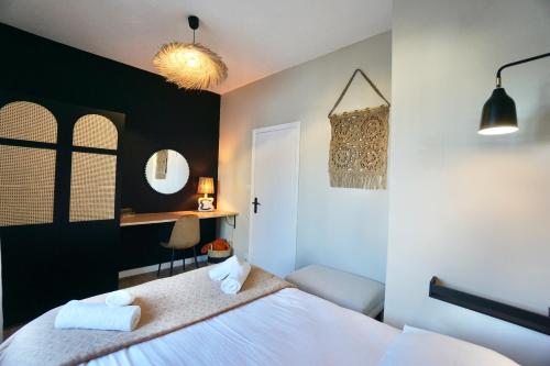 a bedroom with a white bed and a black wall at L'Iconique in Concarneau