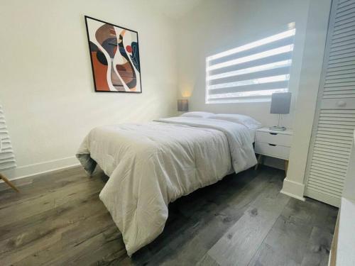 een slaapkamer met een bed en een schilderij aan de muur bij Alma Guest Suite in Miami