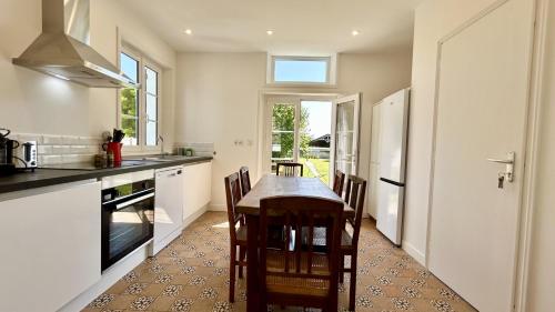 une cuisine avec une table et quelques chaises dans l'établissement Nolette en baie maison de campagne, à Noyelles-sur-Mer