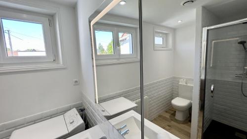 La salle de bains blanche est pourvue d'une douche et de toilettes. dans l'établissement Nolette en baie maison de campagne, à Noyelles-sur-Mer