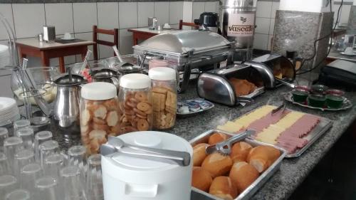a counter top with a bunch of food on it at Hotel Alvorada in Goiânia