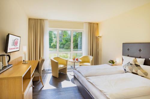 Habitación de hotel con cama y escritorio en Concorde Hotel Viktoria, en Kronberg im Taunus