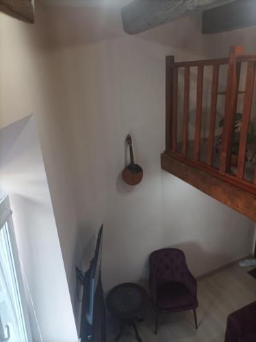 a room with a chair and a guitar on a wall at Chorni vivtsy in Chernivtsi